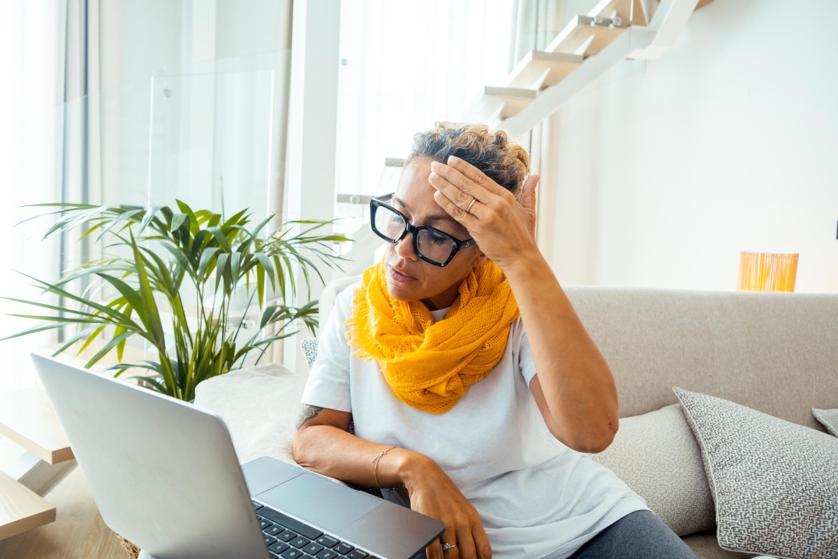 rustrated sad woman feeling tired worried about problem sitting on sofa with laptop