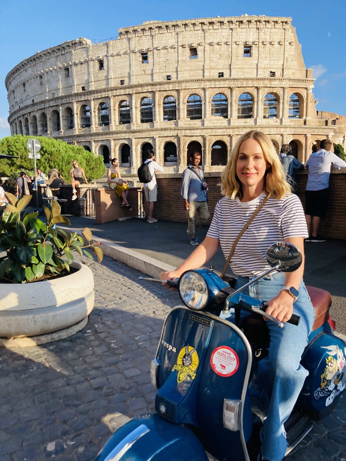 Jo Wood on a vespa scooter in front of the colosseum in Rome